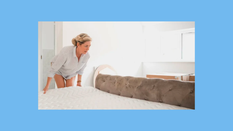 A woman adjusts the bottom of a mattress with her hands.