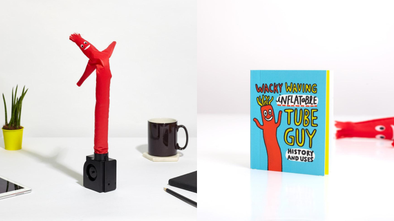 On left, red inflatable tube on top of white table next to black mug, corner of iPad, a pencil and a small potted plant. On right, small book that reads, "Wacky Wavy Inflatable Tube Guy, History and Uses."