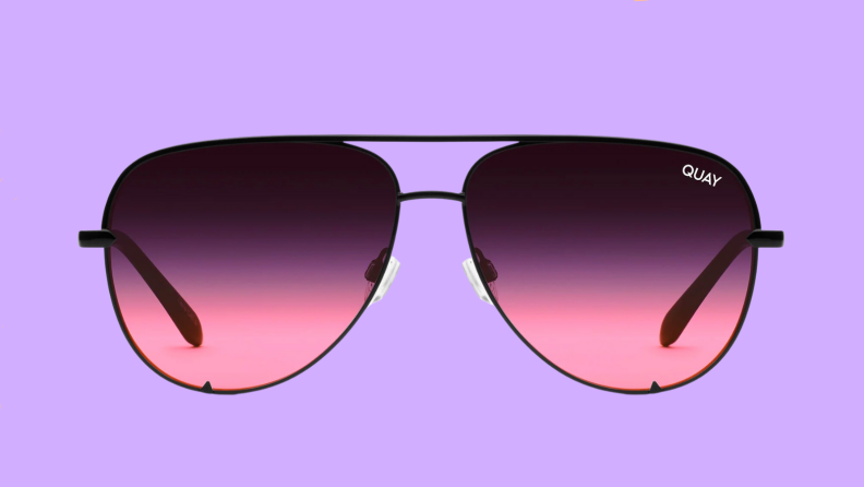 An image of a pair of pink-lensed aviator sunglasses with black, thin frames.