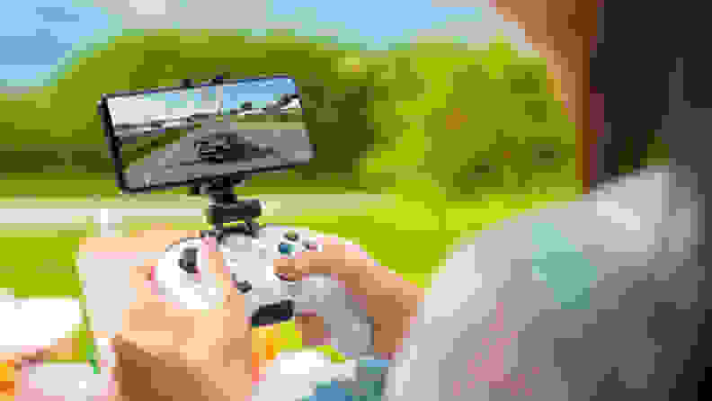 A person playing a video game with an Xbox controller on a mobile phone.