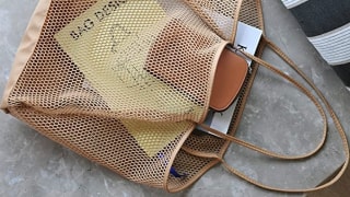 A beach bag being used to store items for a beach trip.
