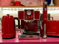 Multiple Galanz countertop appliances, such as, a hand blender, an espresso machine, a toaster, and tea kettle in the color red.