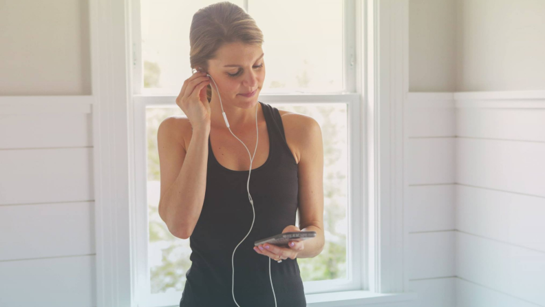 A woman putting in headphones.