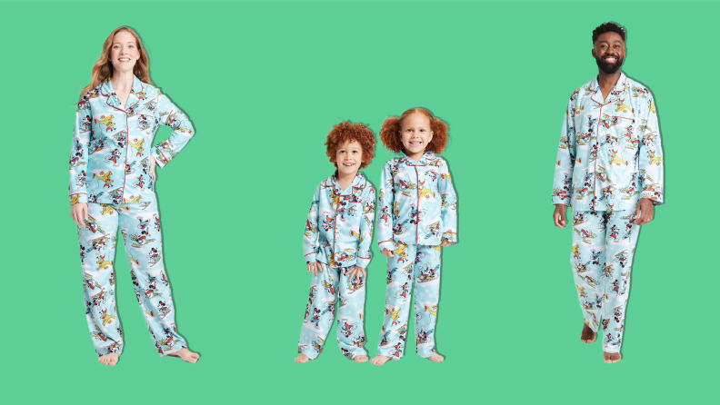 A family wearing the Disney 100 Mickey Mouse & Friends Matching Family Christmas Pajamas on a green background.