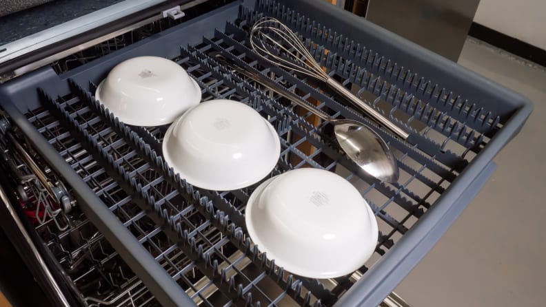The Vinotemp Brama BR-DWSH01-S dishwasher's third rack, featuring severral spoons lying out along its shallow tray, with a few bowls loaded into its sunken middle column.