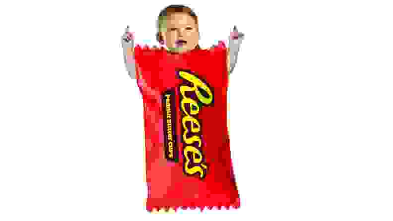 A baby dressed in a Reeses's Cup Halloween costume.