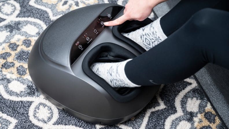 A woman putting her feet in a foot massager.