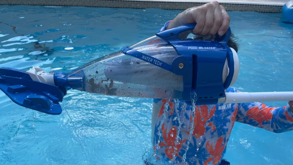 Person standing in pool water holding up the Sharper Image Rechargeable Pool Vacuum.