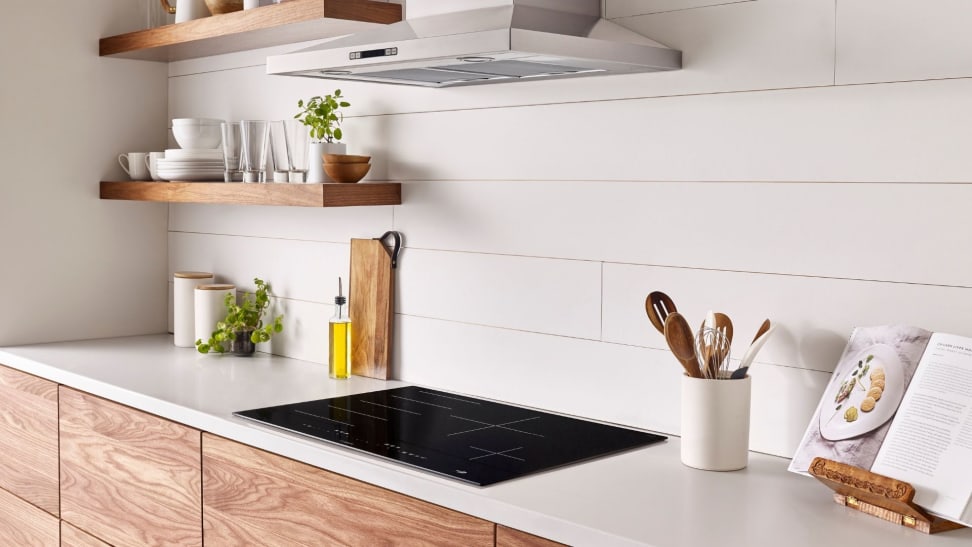 A lifestyle image of a brightly lit, modern kitchen featuring an induction cooktop.