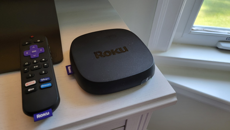 The Roku Ultra and its remote sitting on a white counter top.