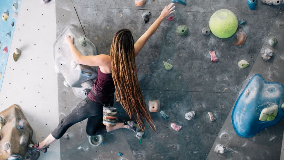 woman rock climbing at climbing gym.
