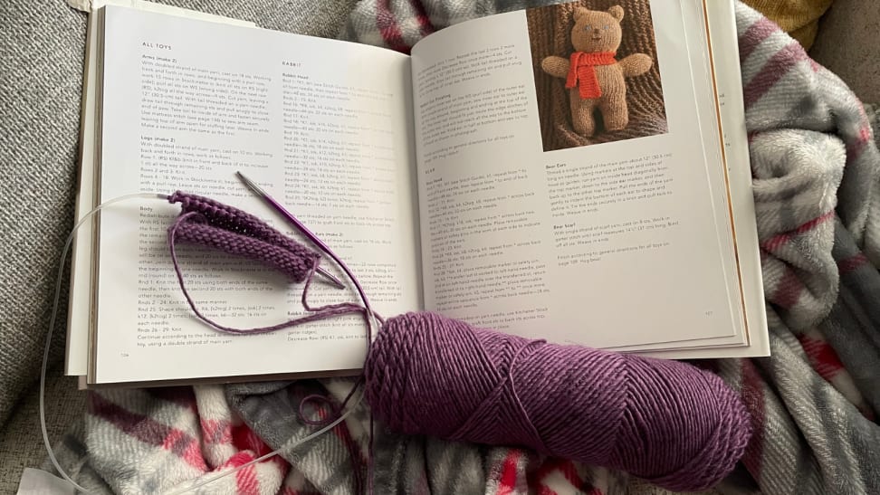 Purple yarn laid out on a knitting book
