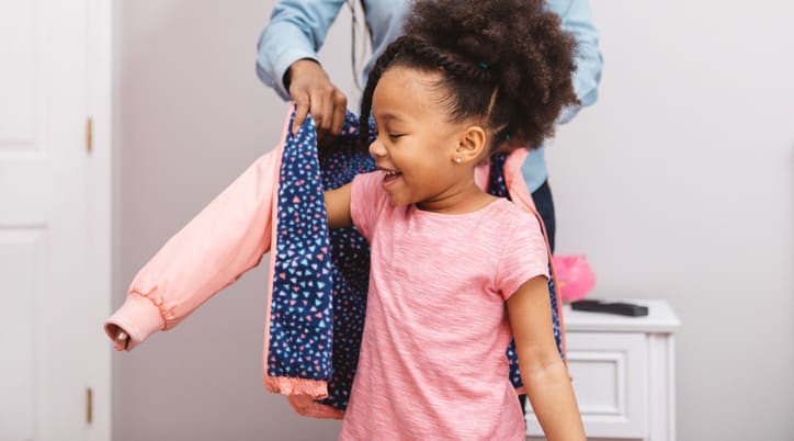 Child putting on coat