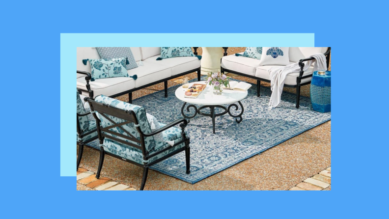 A floral motif print rug against a blue background.