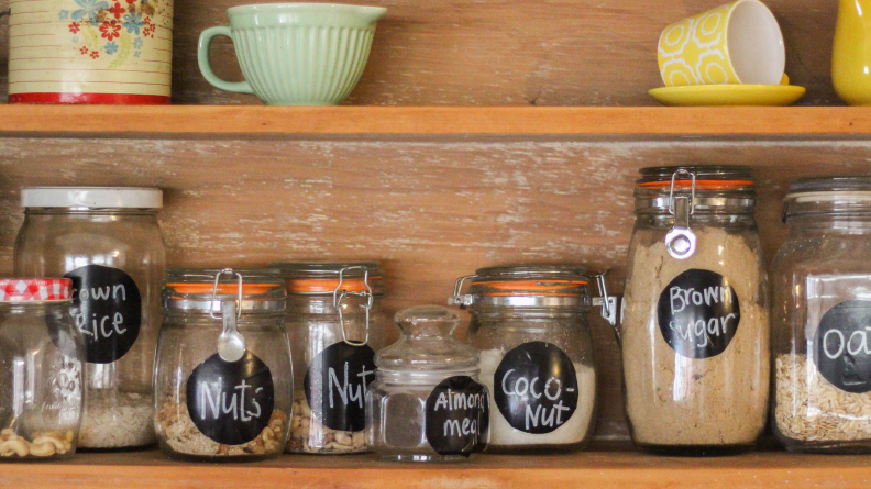 Pantry with glass jars full of healthy nuts and grains.