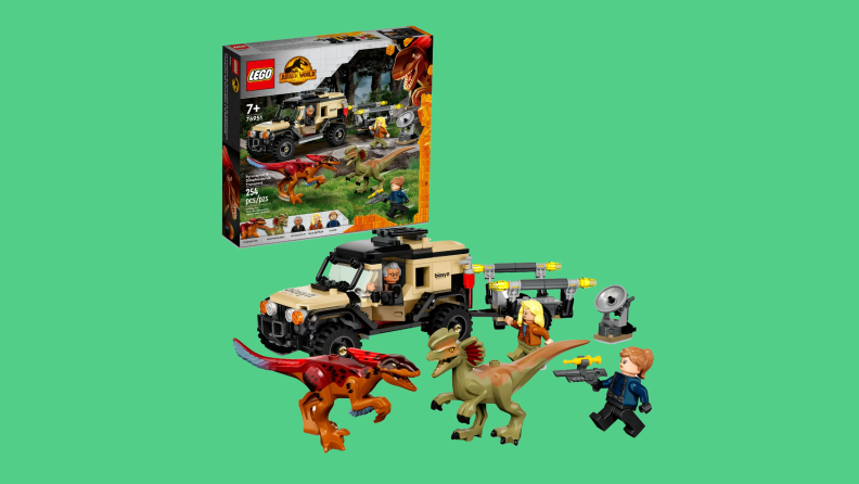 Lego dinosaurs, a lego SUV and lego people shown next to the play set box.