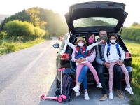 A family wears face masks during a road trip.