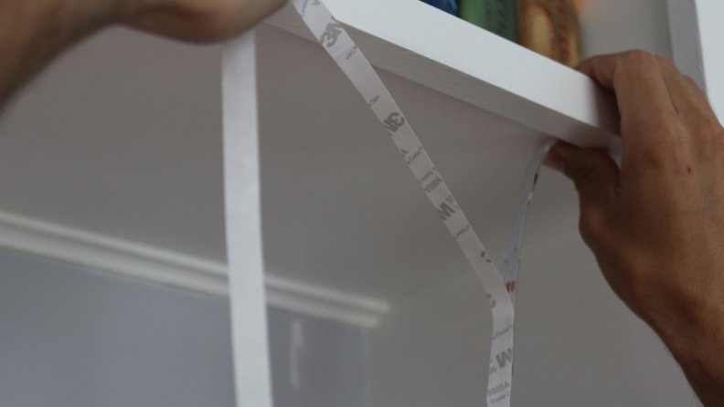 A person installing adhesive smart light strips