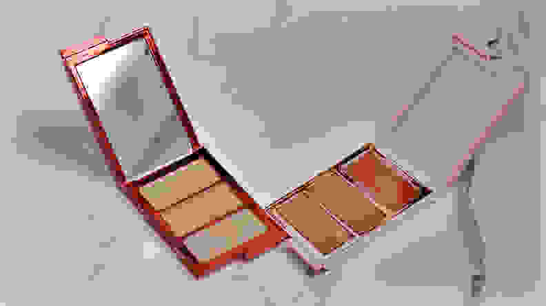 Two open palettes, one a bronze color and the other a light pink color, sit side by side.