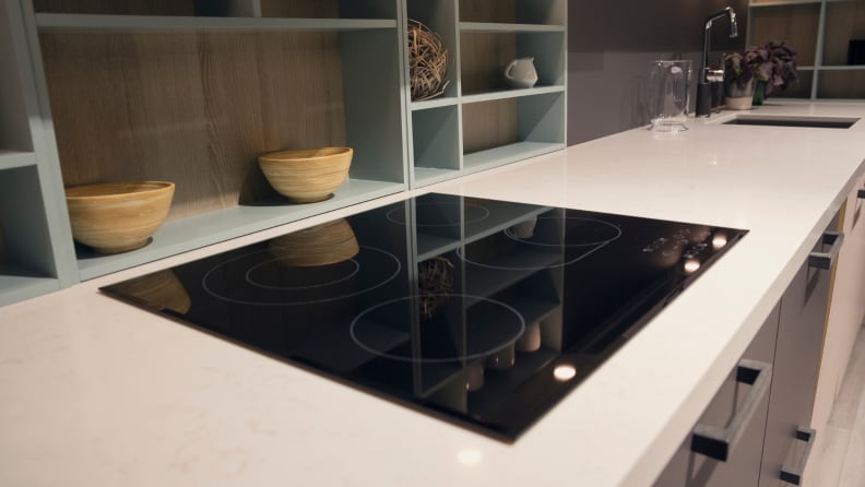 Close up of a black glass stove top on a counter.