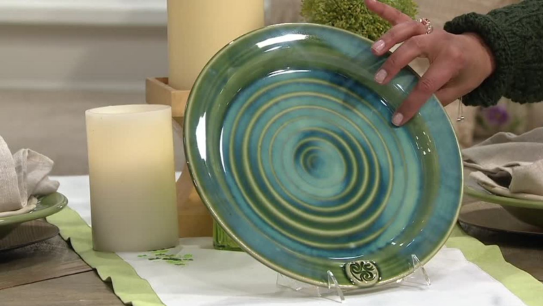 Hand holding up green and blue glazed plate from Colm De Ris