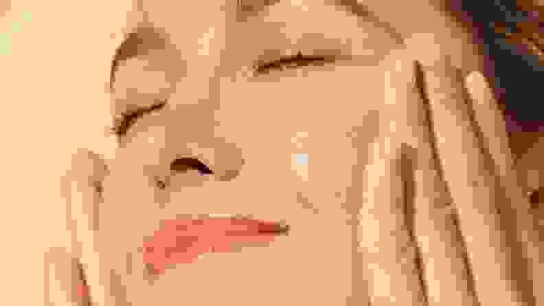 Model applies serum to face