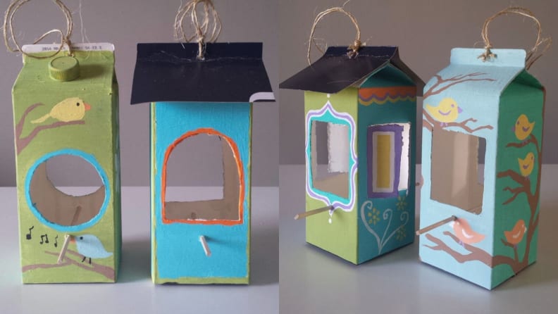 Two bird houses made from empty milk cartons.