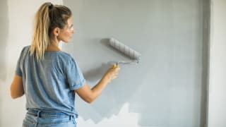 女人在家里刷墙
