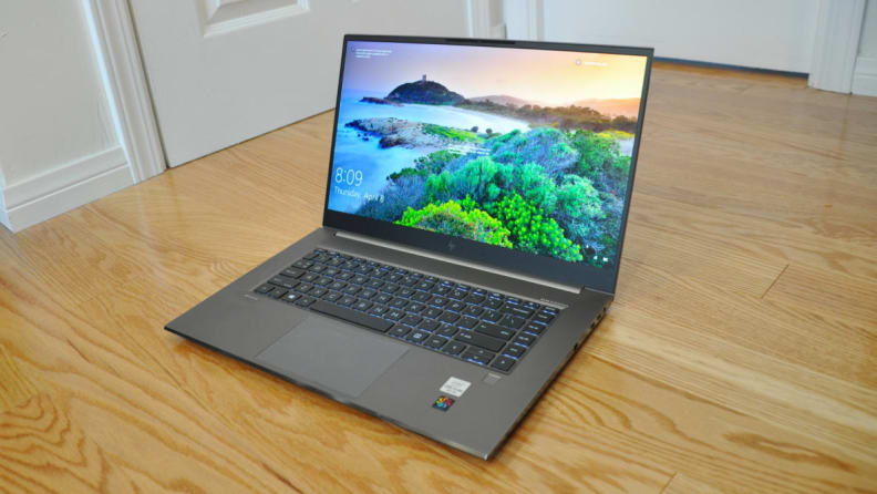 An open laptop sitting on a hardwood floor