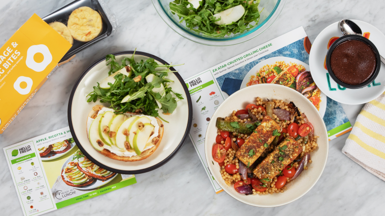 Several laid out HelloFresh meals and recipe cards on a white countertop