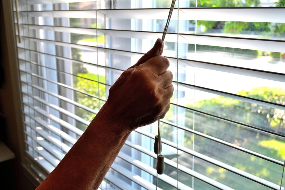 Person holding cord to open blinds