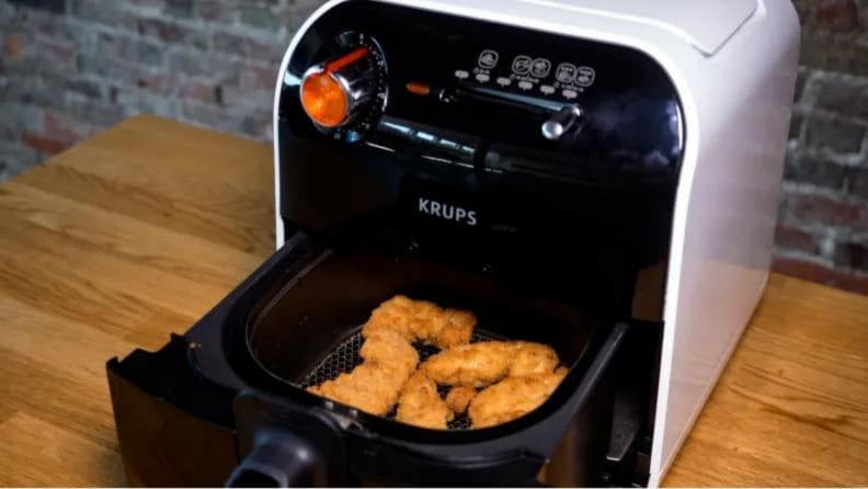 Close an air fryer with the chicken fingers in the basket.
