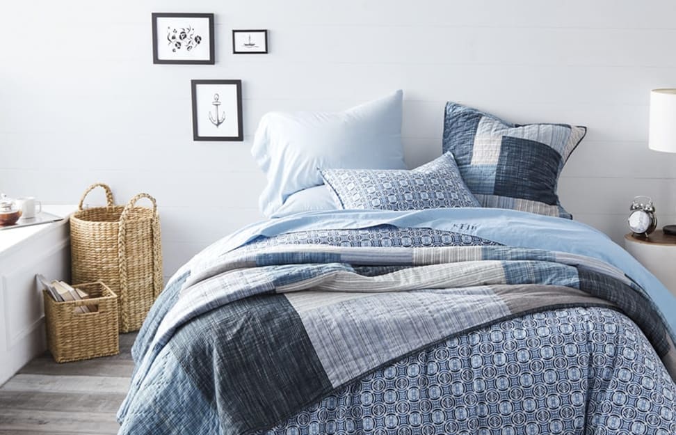 A bedroom with Lands End brand bedding and wicker baskets