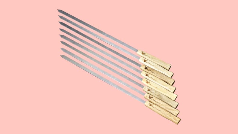 Eight G & F Stainless Steel BBQ Skewers on a pink background.