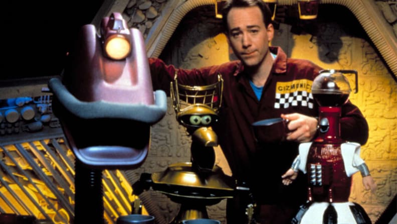 A still from 'Mystery Science Theater 3000' featuring the host and several robots.