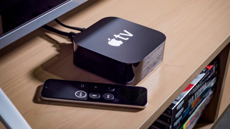 Un Appareil Apple Tv Et Une Télécommande Sont Installés Sous Un Téléviseur.