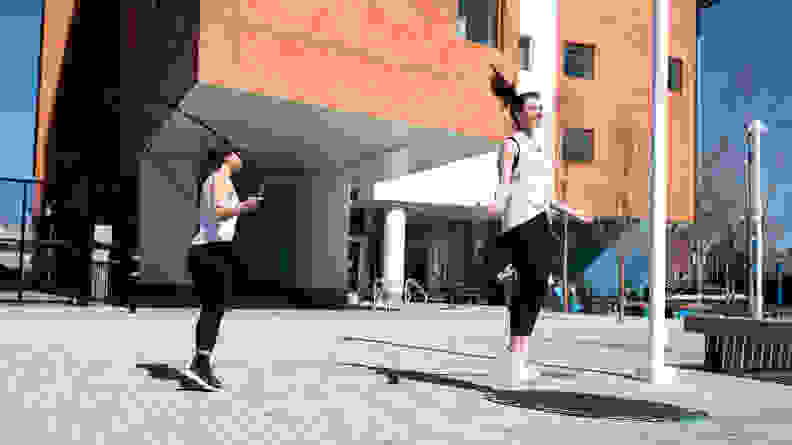 two women jumping rope with crossrope jump ropes outside