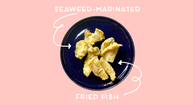 Fried fish on a blue plate on a pink background.