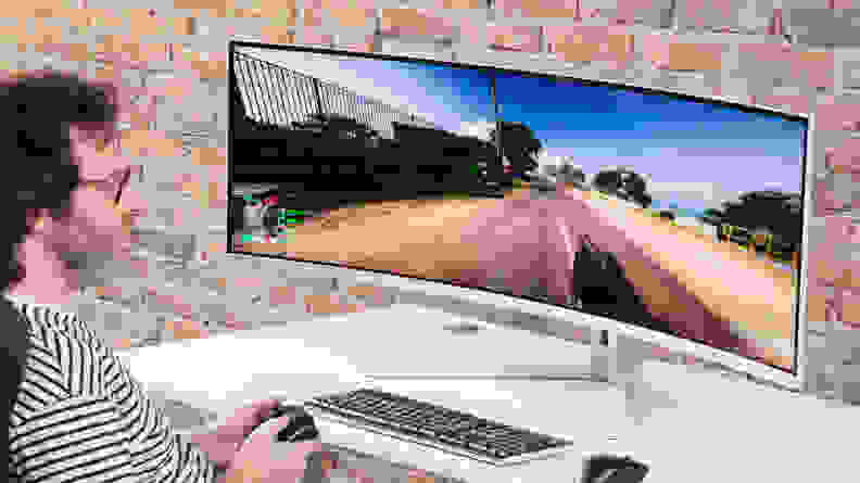 A person playing an FPS in front of the Philips Evnia 49M2C8900.