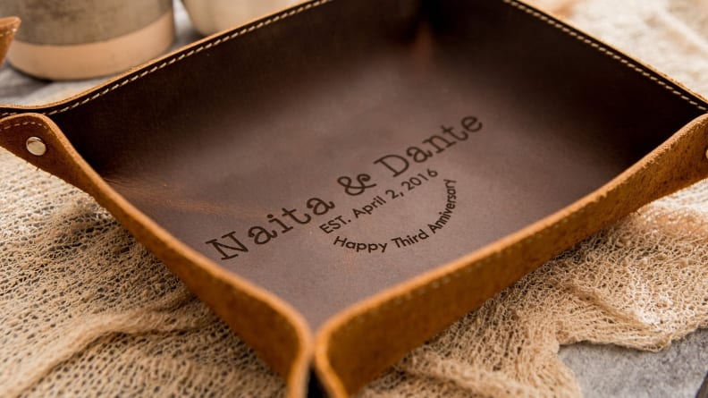 Leather square shaped dish on a light woven cloth.