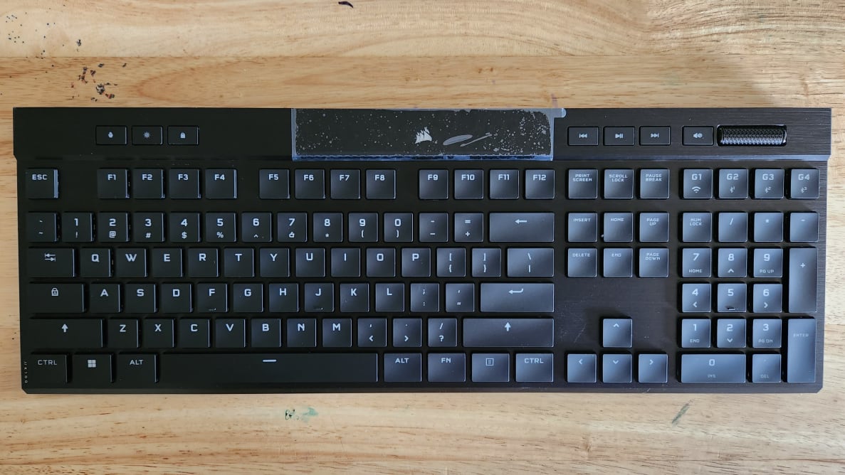 A black keyboard on top of a beige wooden desk