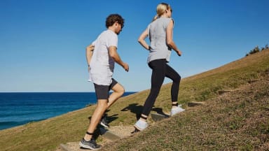 Two walkers climbing a hill wearing Evolve Mvmt step trackers.