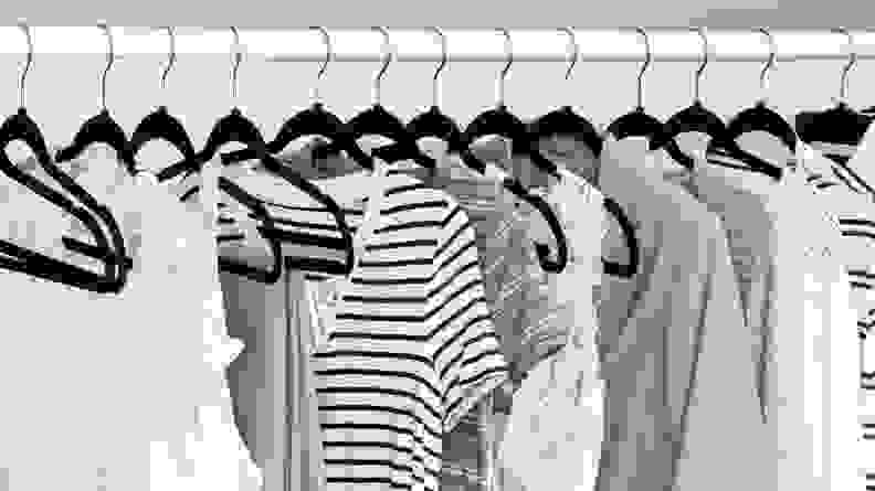 Clothes in closet on black hangers.