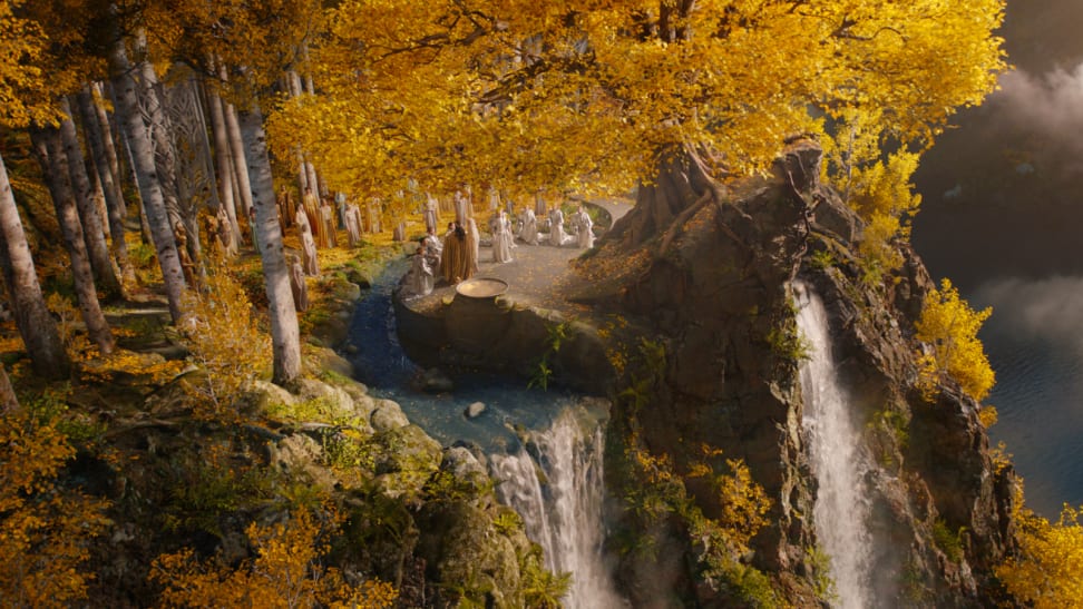 An image of the golden-leafed trees of Lindon, with several Elves standing on a plinth overlooking a waterfall. The Elves stand in a semicircle around the High King Gil-Galad.