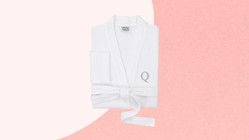 Folded white bathrobe with letter Q monogram