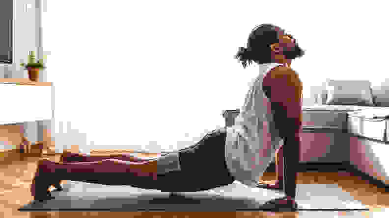 一个穿着眼镜蛇的男人在瑜伽垫上摆姿势。