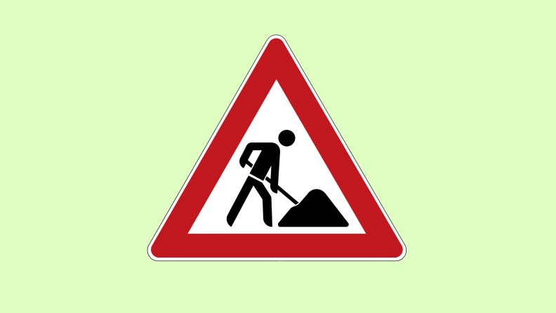 A triangular yield sign with a graphic of a person shoveling