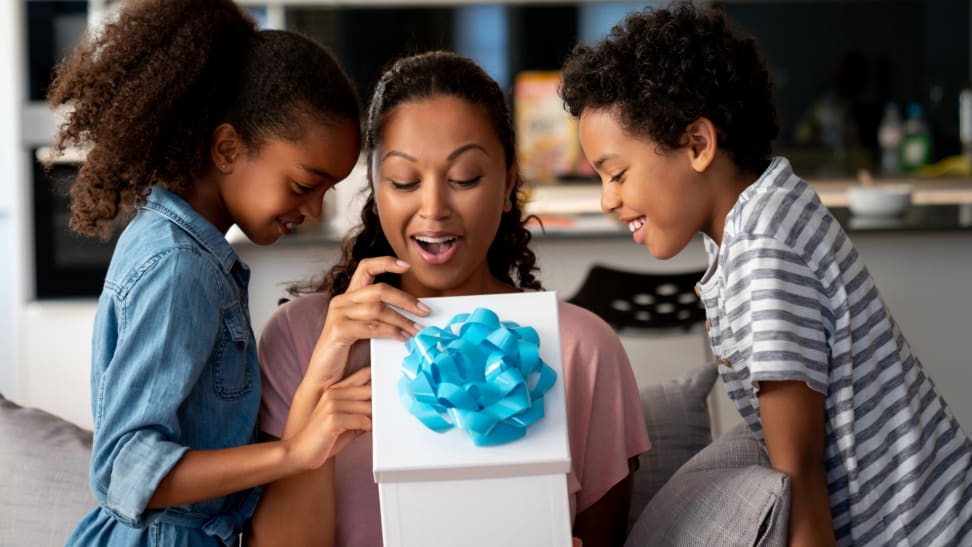 A woman and two children opening a gift