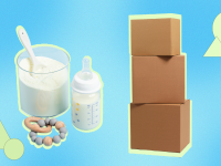 Powdered baby formula next to teething ring, baby bottle and three stacked shipping boxes.