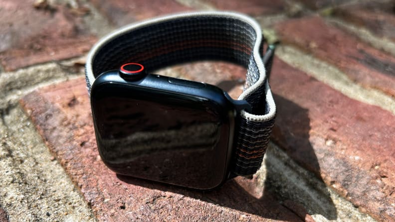 A midnight blue Apple Watch sits on a brick wall.
